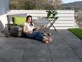 Une jeune femme lit sur une terrasse en dalles imitation ardoise Alpine Black