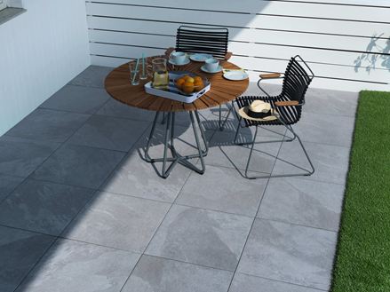 Terrasse avec du mobilier de jardin et des dalles gris clair effet ardoise