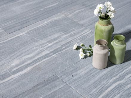 Trois vases à fleurs sur dalles de calcaire en gris clair avec des veines blanches
