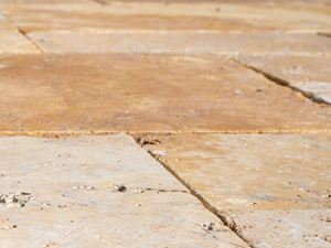 Gros plan sur les dalles de terrasse en travertin Gold