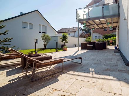 Terrasse ensoleillée avec deux transats et sol en travertin Medium