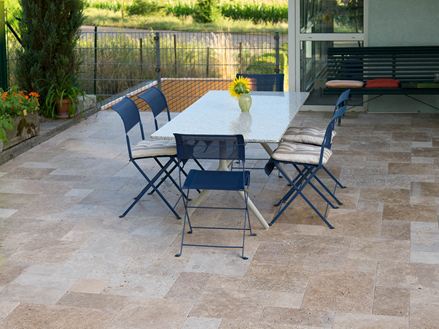 Terrasse avec sol en travertin Noce et coin repas