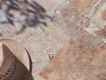 Terrasse en travertin Scabas au soleil avec chapeau de paille