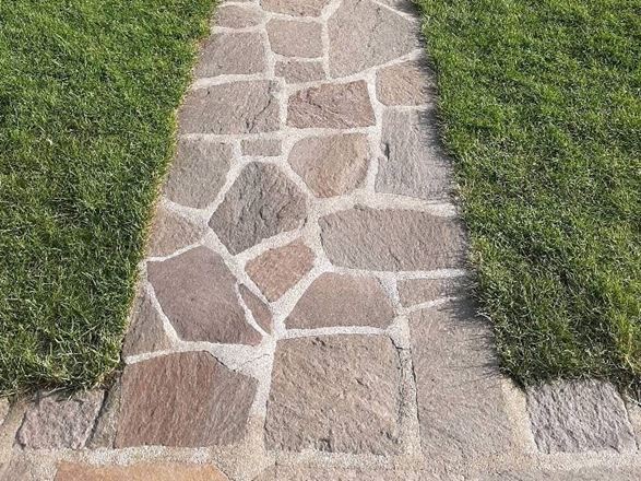 Les dalles polygonales en porphyre Terra entourée de gazon