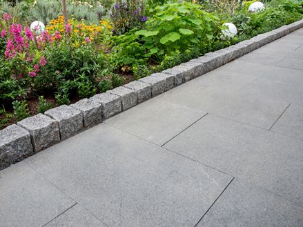 A l'écart avec dalles de granit et parterre de fleurs attenant