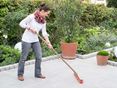 Une femme nettoie une terrasse en granit