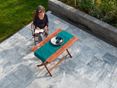 Se détendre avec style sur une terrasse Afyon Grey ! (projet client) Femme assise à une table en bois sur une terrasse avec des dalles de marbre