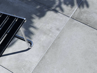 Le dallage imitation béton Ombra avec une chaise de jardin