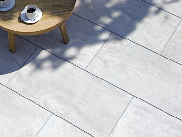 Les dalles de terrasse imitation quartzite Monro Light et une table ronde vues de dessus