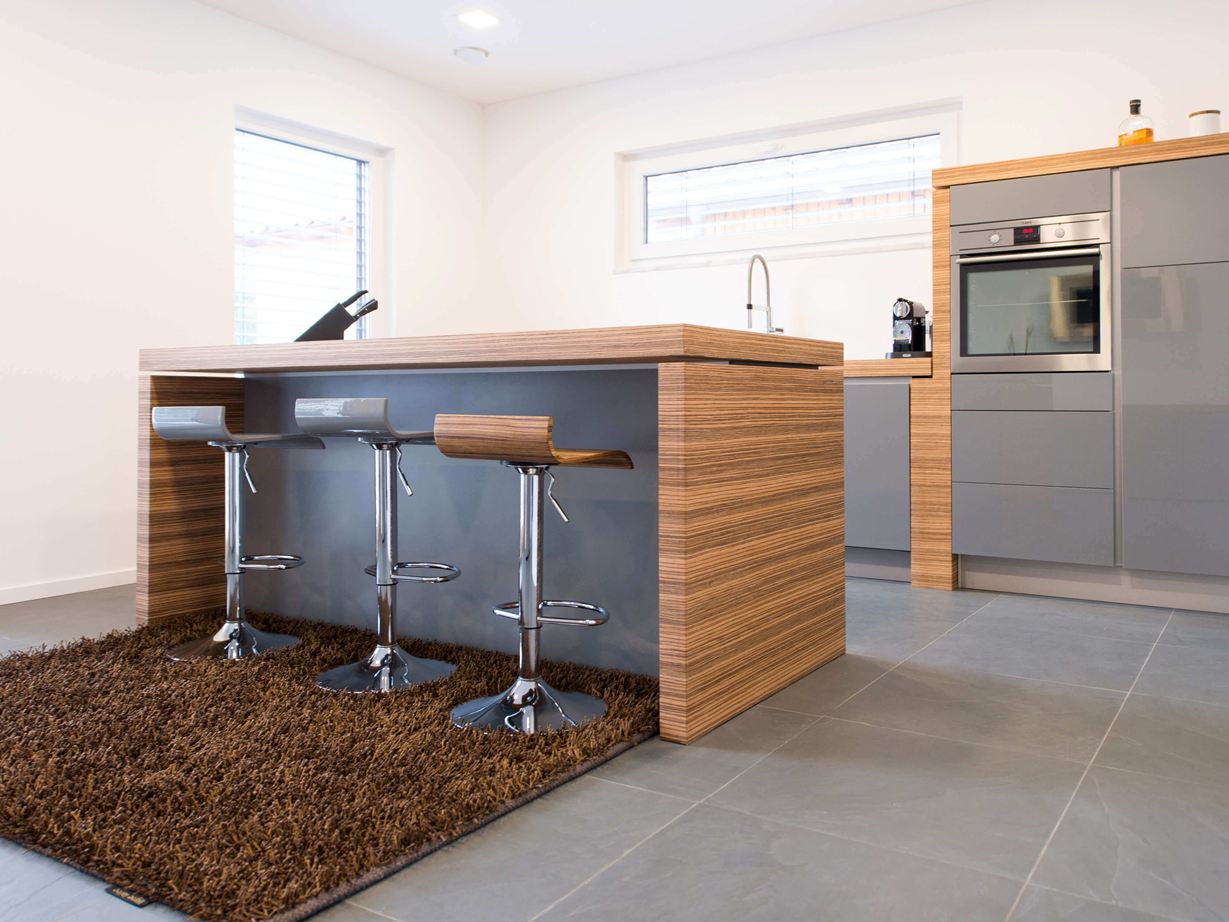 La cuisine ouverte avec un bar et des éléments en bois moderne, en plus un sol en ardoise