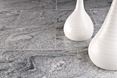 Carreaux de granit gris à grains foncés et clairs et deux vases décoratifs blancs