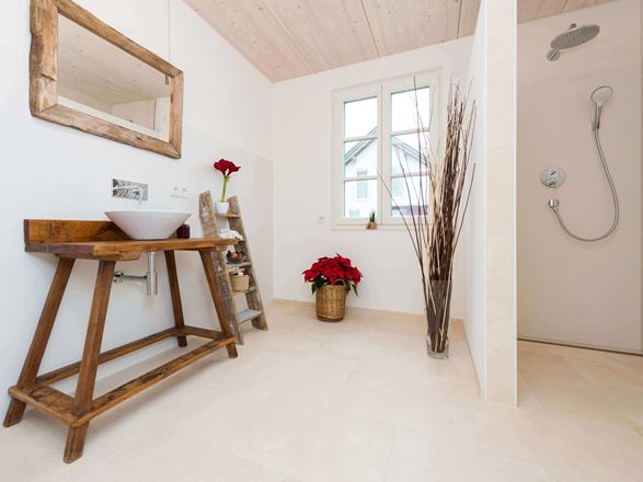 Salle de bain moderne avec carrelage clair en pierre calcaire et meubles en bois