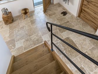 Le carrelage en travertin Classic Country vu de haut depuis l'ecalier en bois