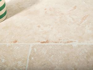 L'ombre d'un pot de fleurs sur le carrelage en travertin Ivory Cream