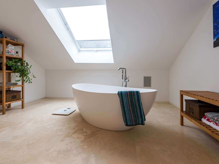 Salle de bain avec travertin Medium Line, baignoire sur pied et serviette de toilette