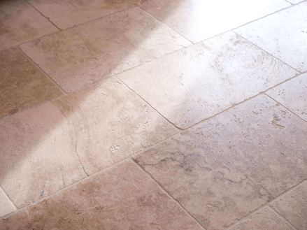 Carrelage en travertin rustique dans l'ombre avec faisceau de lumière