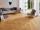 Canapé moderne gris avec fauteuil sur carrelage en grès cérame aspect bois Urban Honey dans salon lumineux