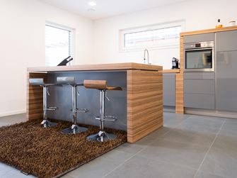 La cuisine ouverte avec un bar et des éléments en bois moderne, en plus un sol en ardoise