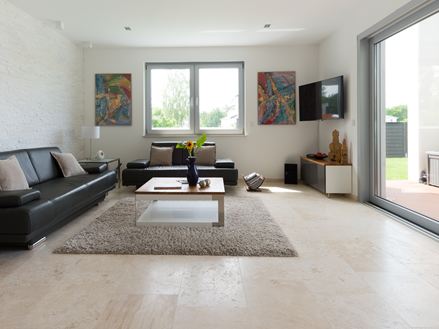 Séjour moderne avec canapé noir et carreaux de travertin beige clair Classic Light comme revêtement de sol